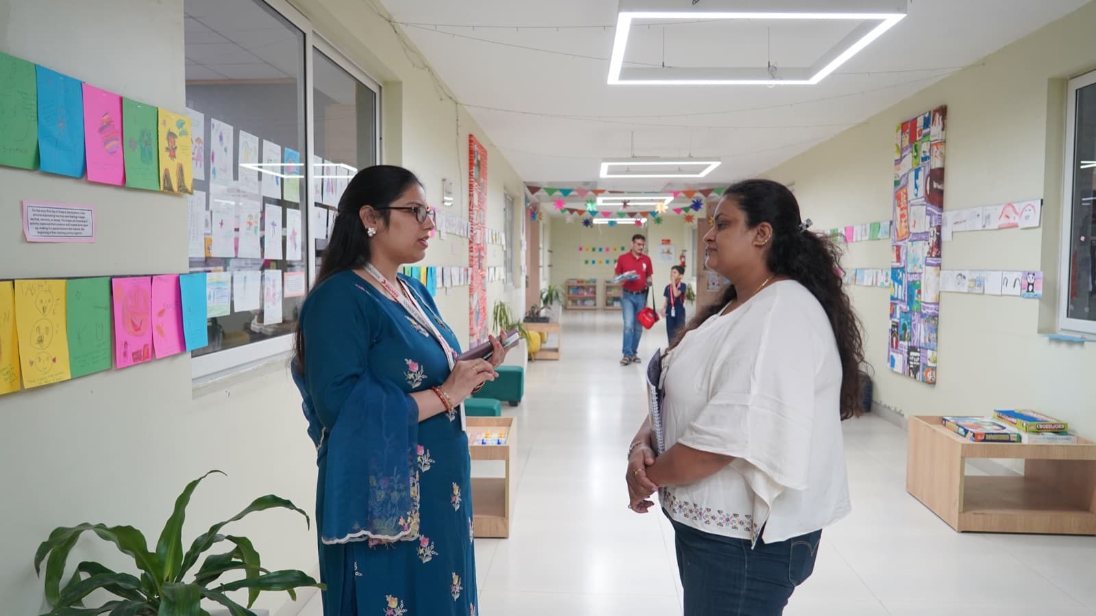 A parent being shown around a KWS corridor lined with student artwork